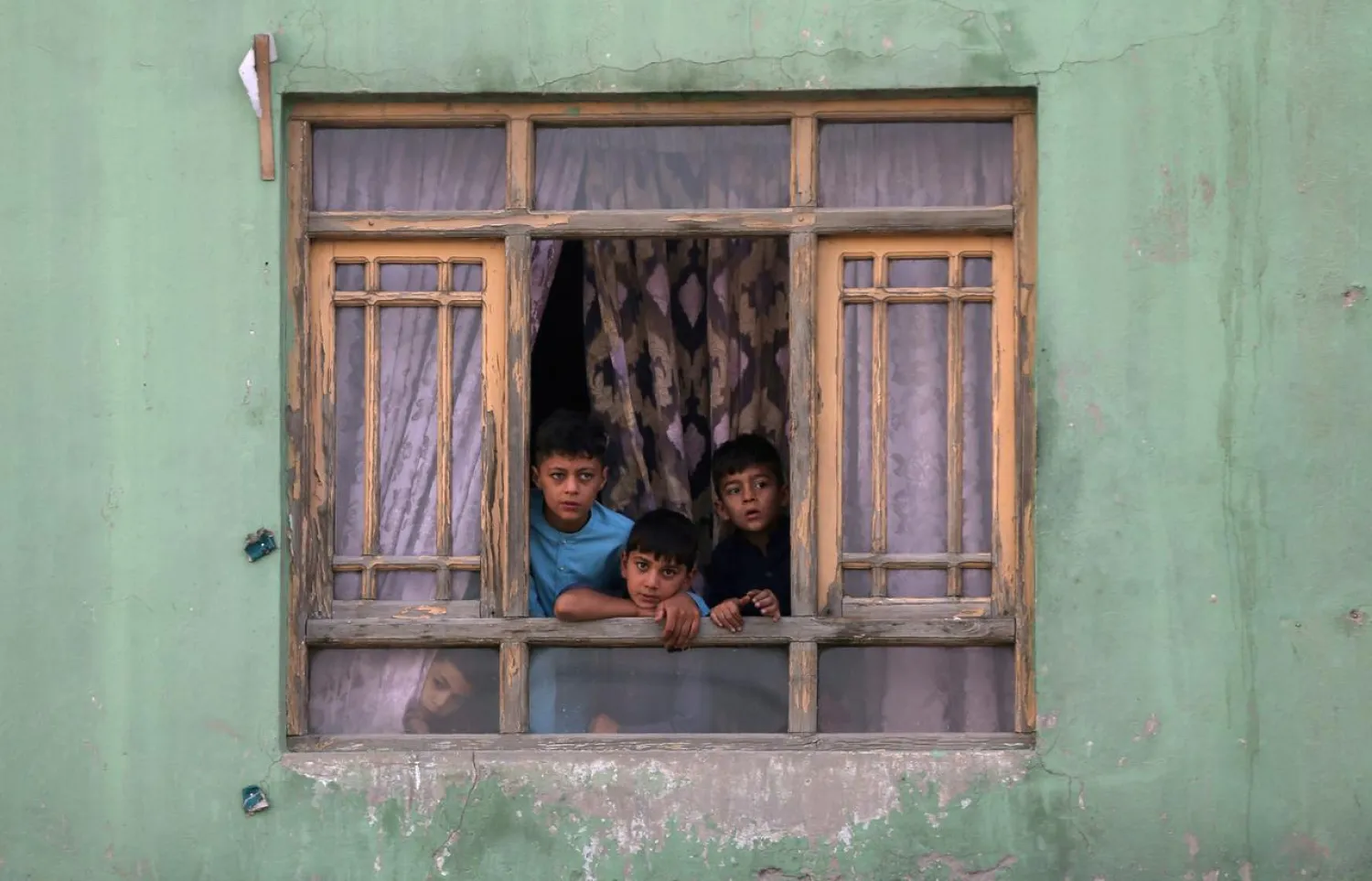 Afghan children look out from a broken window at the site of a blast in Kabul, Afghanistan September 3, 2019. REUTERS/Omar Sobhani/File Photo