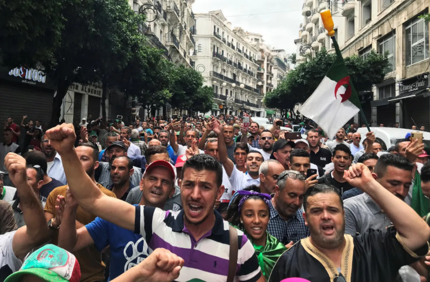 متظاهرون خلال إحدى المسيرات في الجزائر (رويترز)