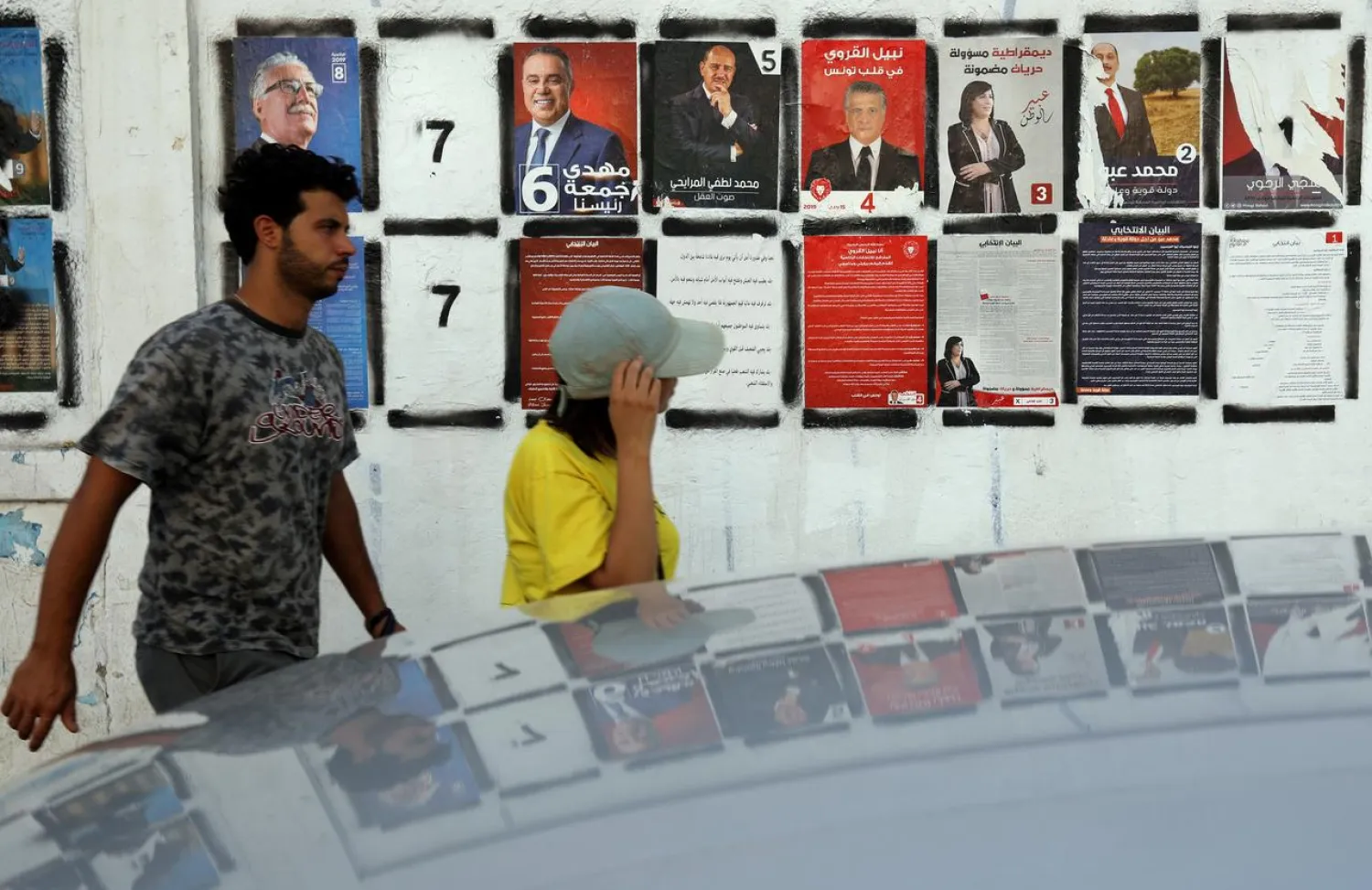 People walk past election campaign posters for presidential candidates in Tunis, Tunisia, September 13, 2019. (Reuters)
