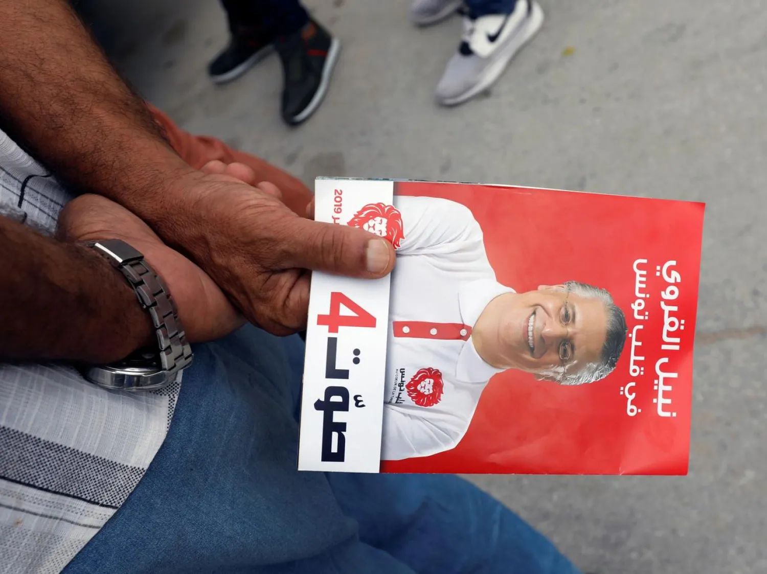 A supporter of presidential candidate Nabil Karoui holds a leaflet during a campaign in Tunis, Tunisia September 10, 2019. Picture taken September 10, 2019. (Reuters)