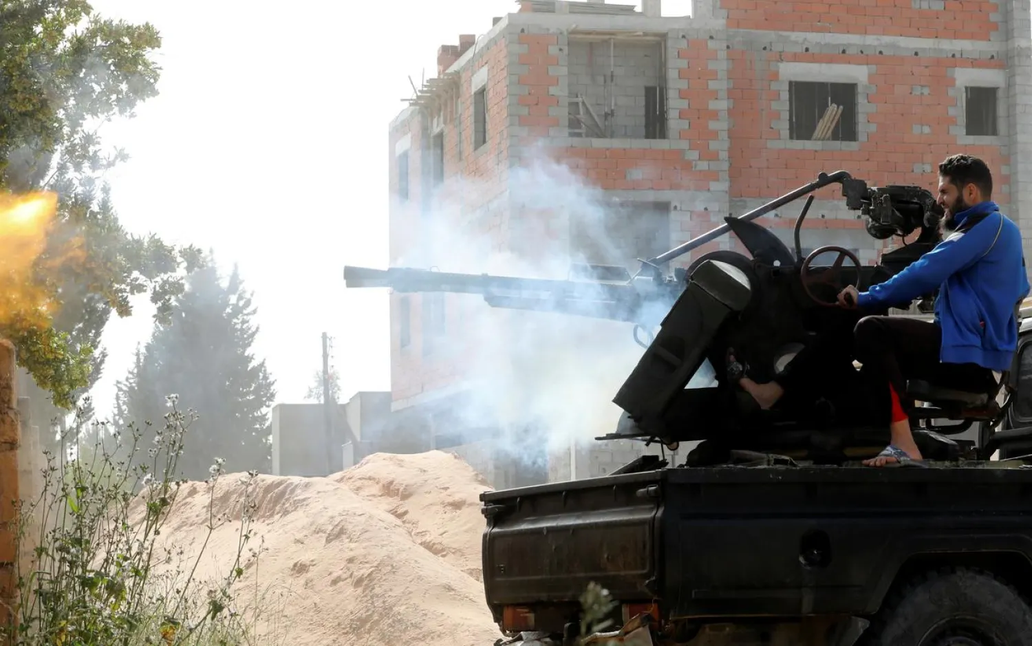 A GNA member fires during a fight with LNA forces in Ain Zara, Tripoli, Libya April 25, 2019. REUTERS/Hani Amara