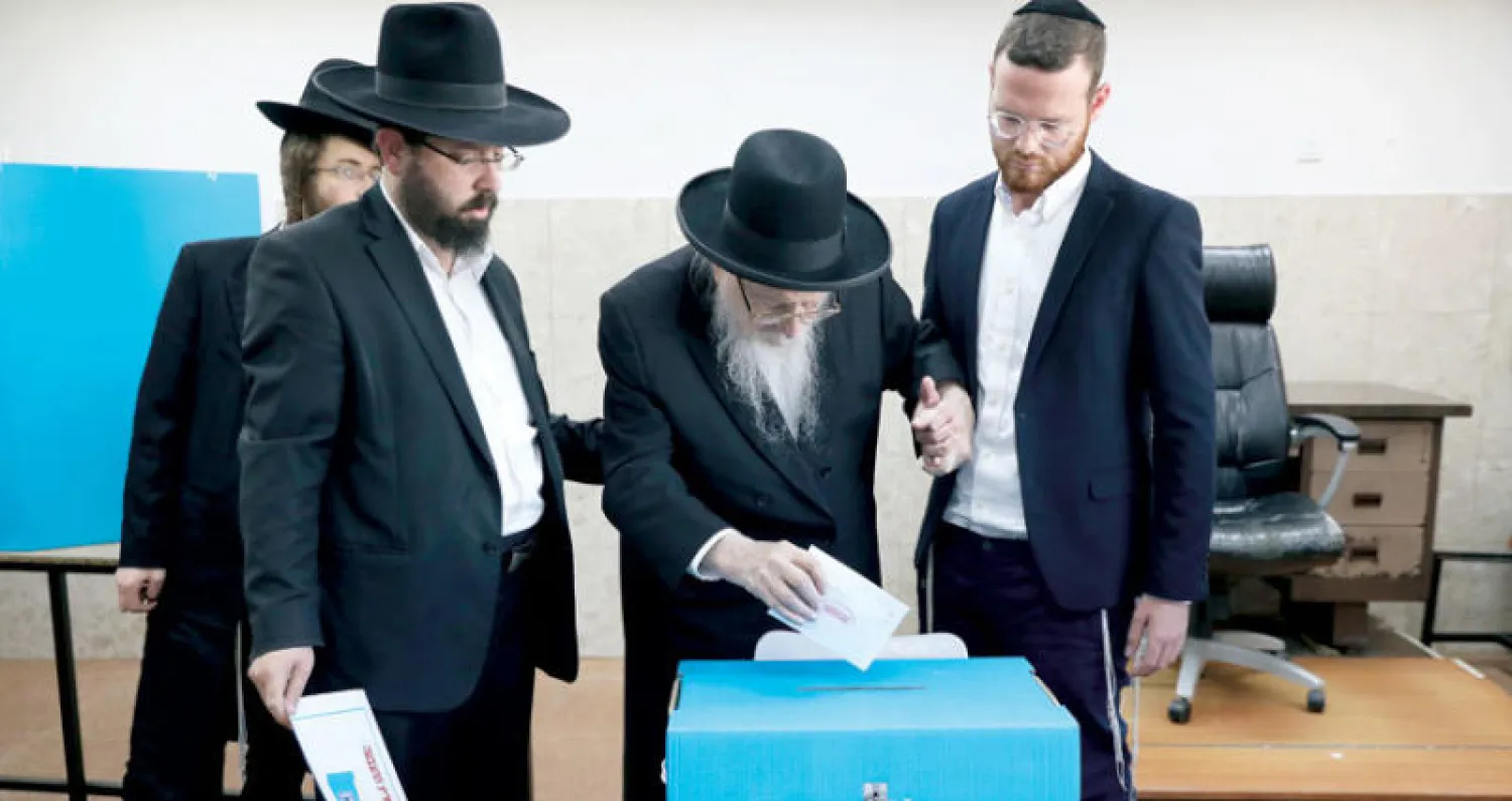 يهود متدينون خلال التصويت في مركز اقتراع في القدس أمس (رويترز)