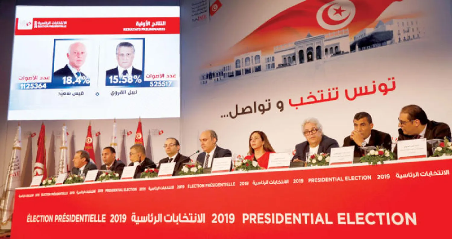 جانب من مؤتمر إعلان نتائج الانتخابات في تونس أمس ويبدو المرشحان المتصدران على الشاشة (رويترز)