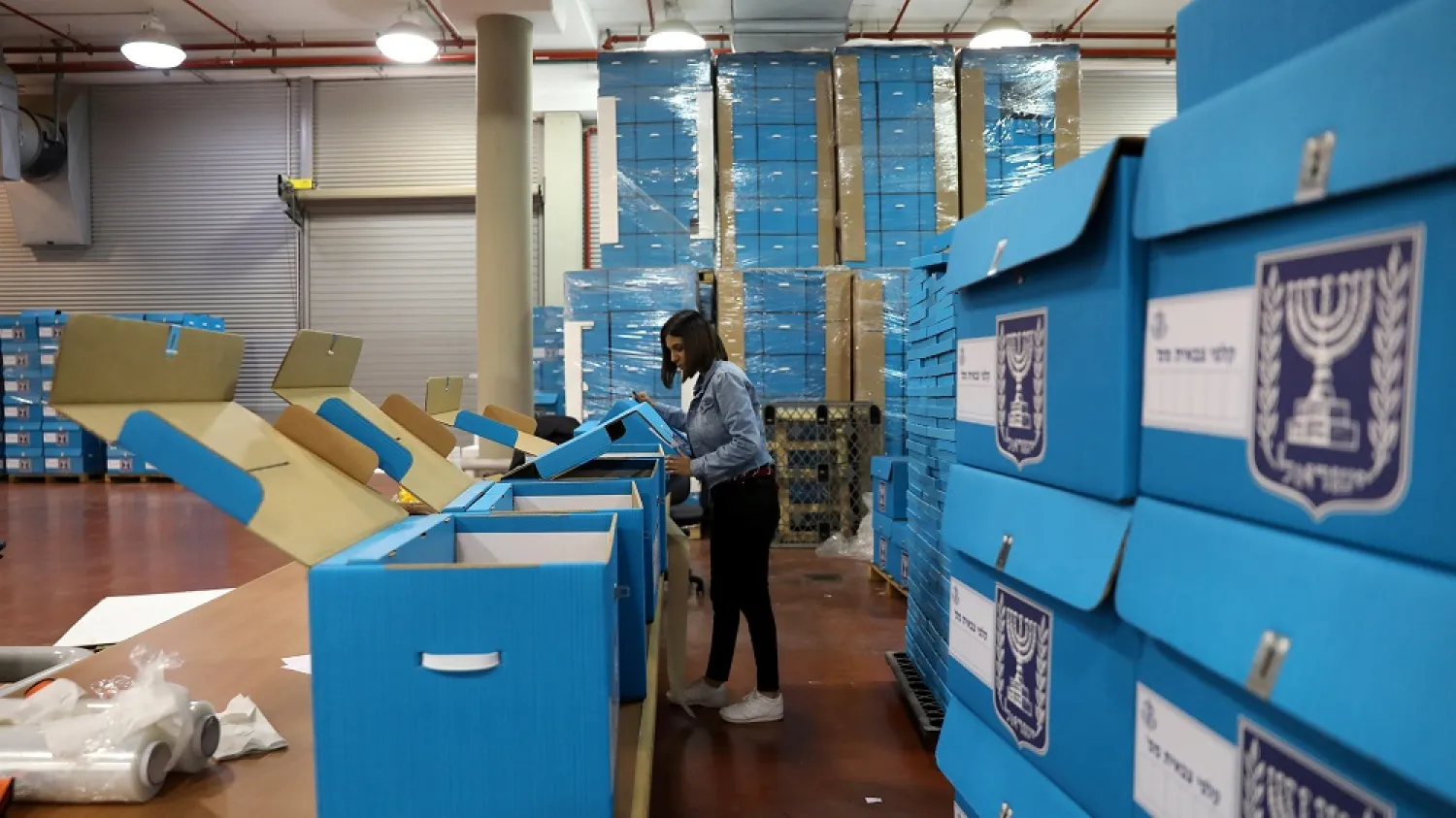 A woman sorts ballot boxes for Israeli election during a briefing for members of the media at the Israel Central Election Committee Logistics Center, Shoham, March 6, 2019. (Reuters)