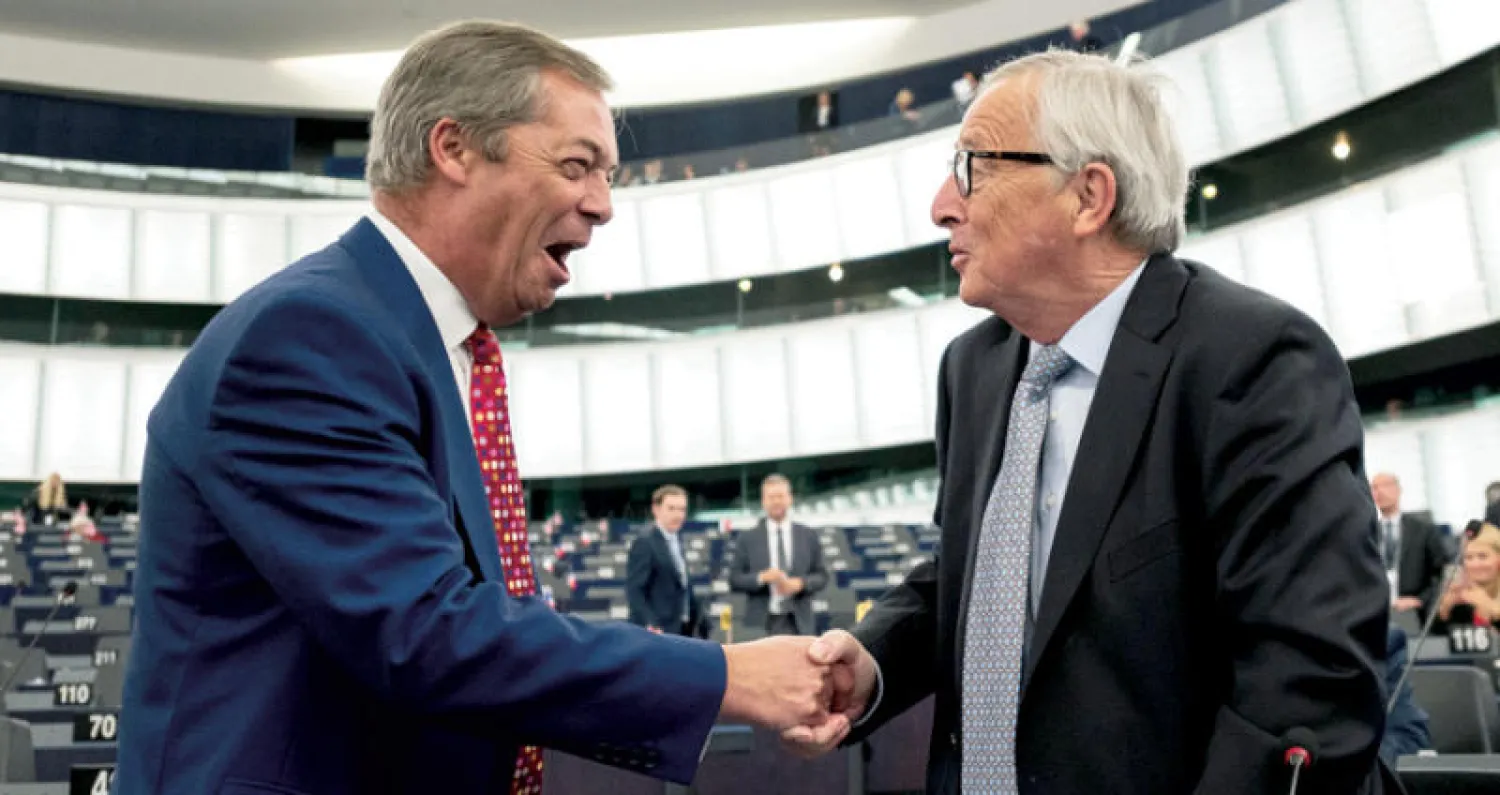 فاراج يصافح يونكر قبل انطلاق النقاش في البرلمان الأوروبي أمس (إ.ب.أ)