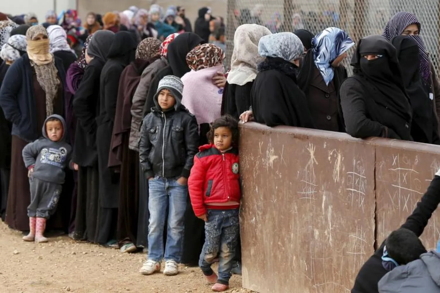 Syrian refugees stand in line as they wait for aid packages at Al Zaatari refugee camp in the Jordanian city of Mafraq, near the border with Syria, January 20, 2016. REUTERS/ Muhammad Hamed
