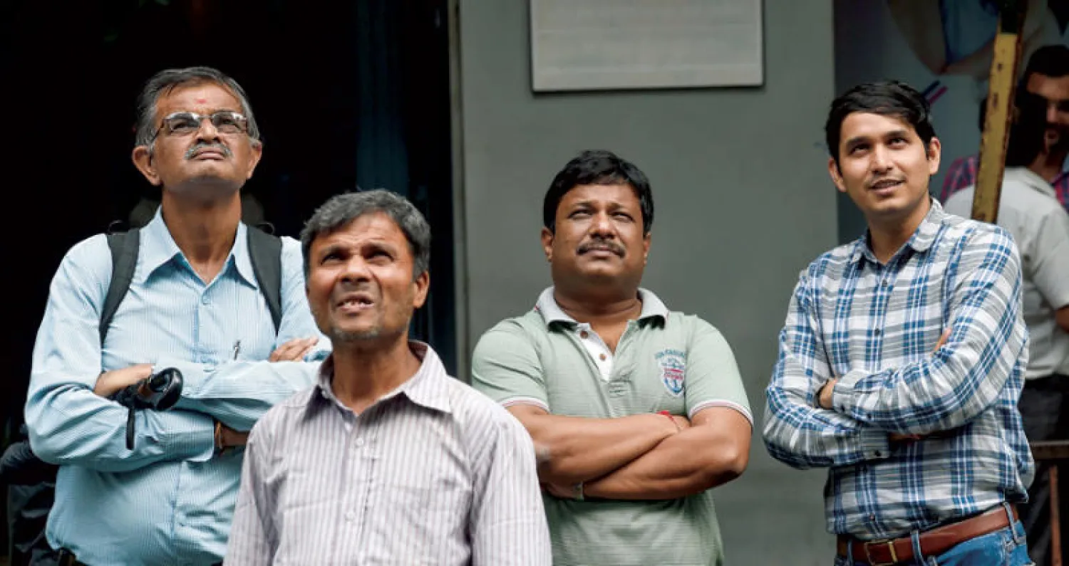 مواطنون يراقبون صعود أسعار الأسهم في «بورصة بومباي» الهندية أمس عقب إعلان القرارات الاقتصادية (أ.ف.ب)