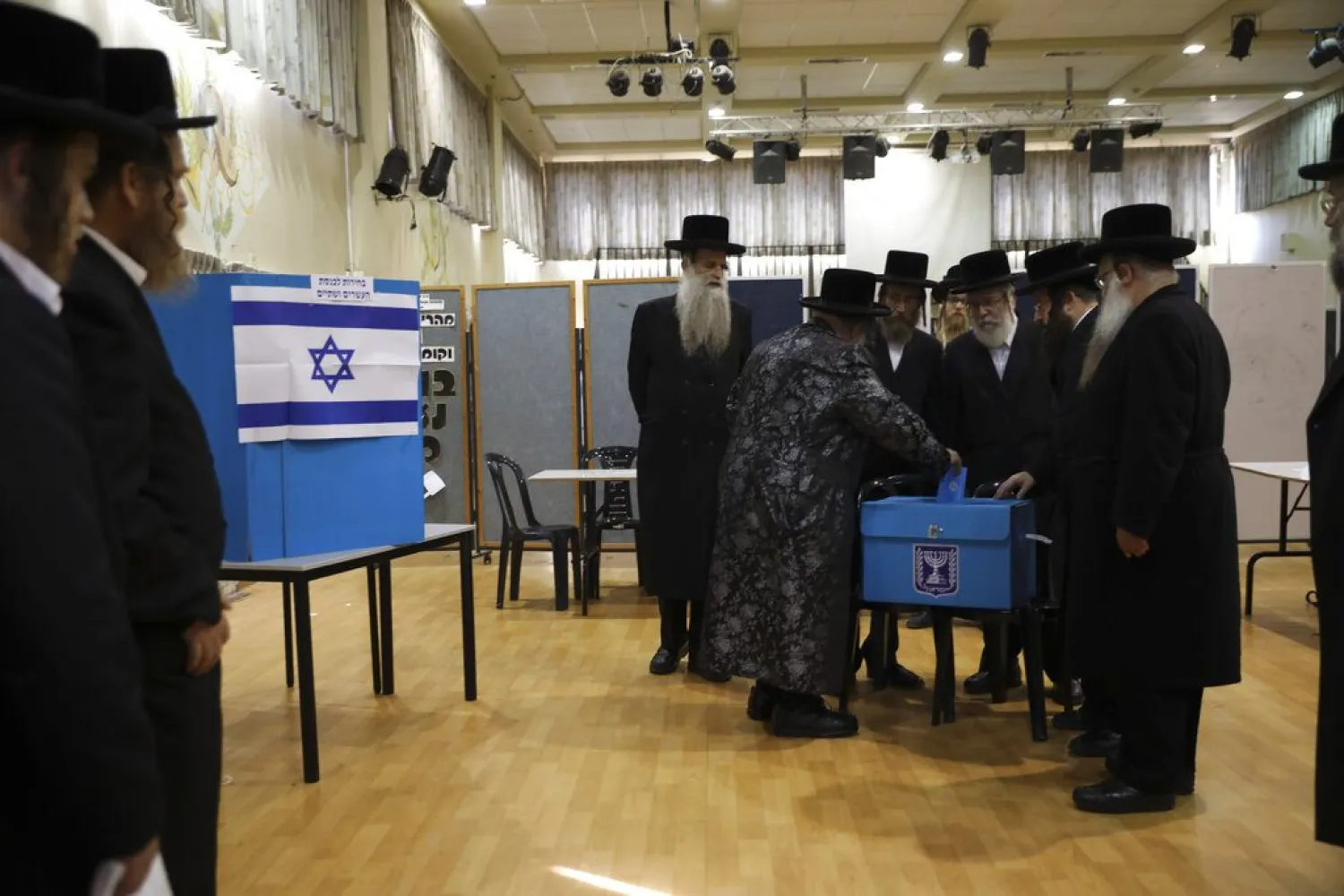 In this Tuesday, Sept. 17, 2019 file photo, ultra-Orthodox Jews watch Rabbi Israel Hager vote in Bnei Brak (AP Photo/Oded Balilty, File)
