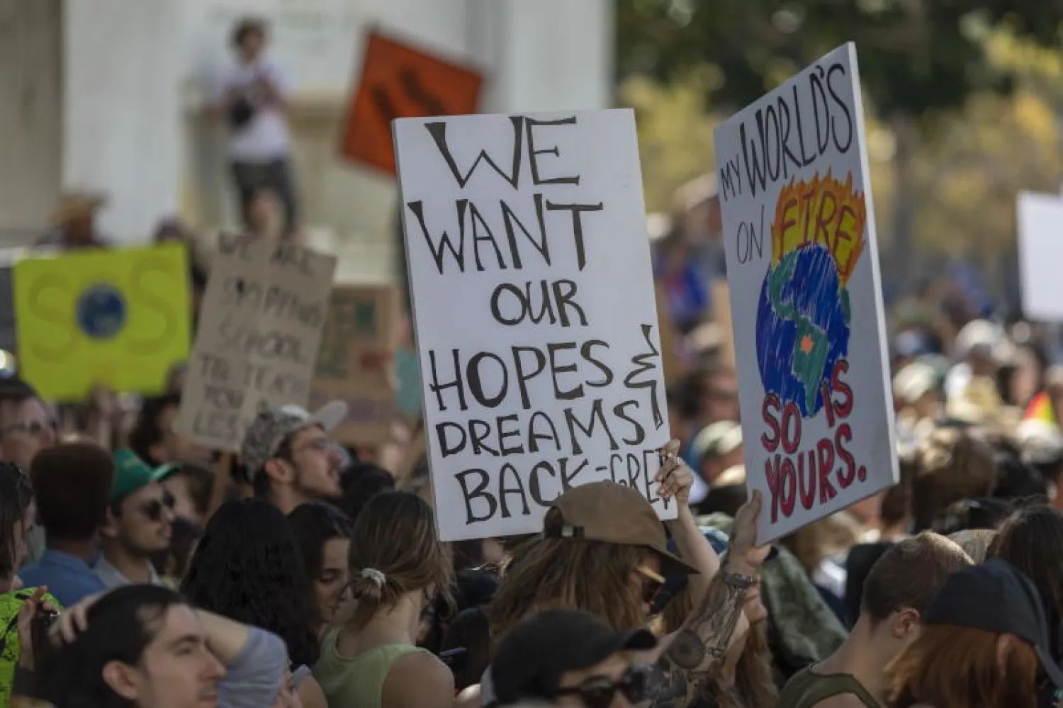 متظاهرون في كاليفورنيا يحملون يافطات تحذر من التغير المناخي الحاصل في جميع أنحاء العالم (إ.ب.أ)