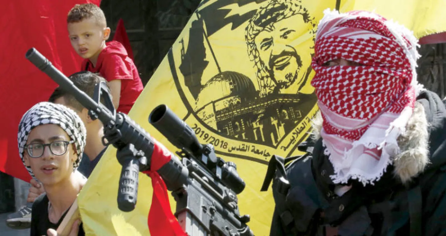 مسلحون فلسطينيون يشاركون أمس في مراسم تشييع الطفل نسيم أبو رومي (14 سنة) في بلدة العيزرية بالضفة الغربية المحتلة. وقتل جنود إسرائيليون نسيم خلال محاولته طعن رجال شرطة في القدس في أغسطس (آب) الماضي، وكانت جثته محتجزة لدى سلطات الاحتلال حتى الآن (أ.ف.ب)