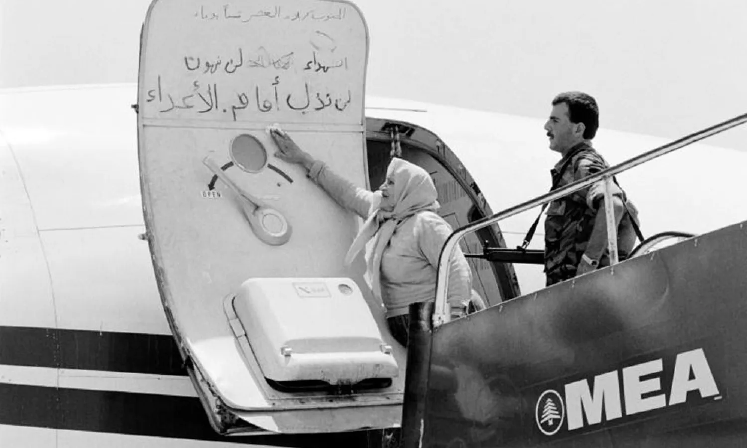 A Lebanese woman cleaning slogans written by the hijackers. (AFP)