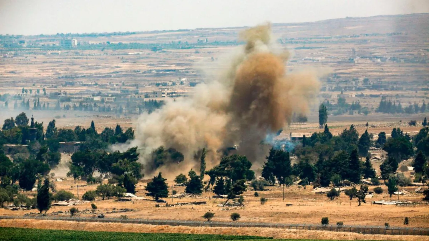 A picture taken on July 22, 2018 from the Israeli-occupied Golan Heights shows a smoke plume rising across the border in Quneitra in southwestern Syria. (AFP)