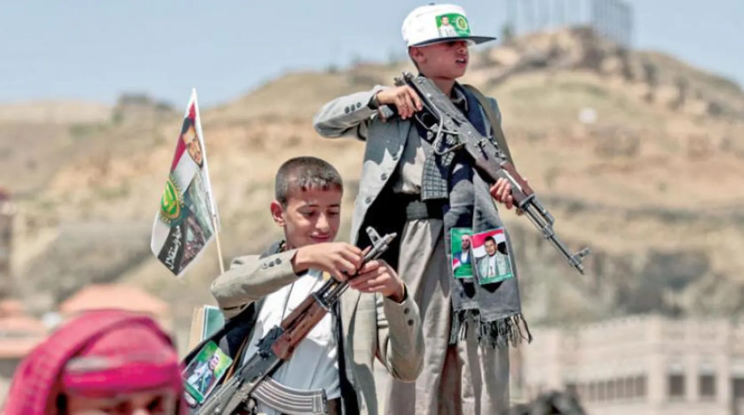Two Yemeni children holding weapons in an armed gathering in Sanaa (AFP)