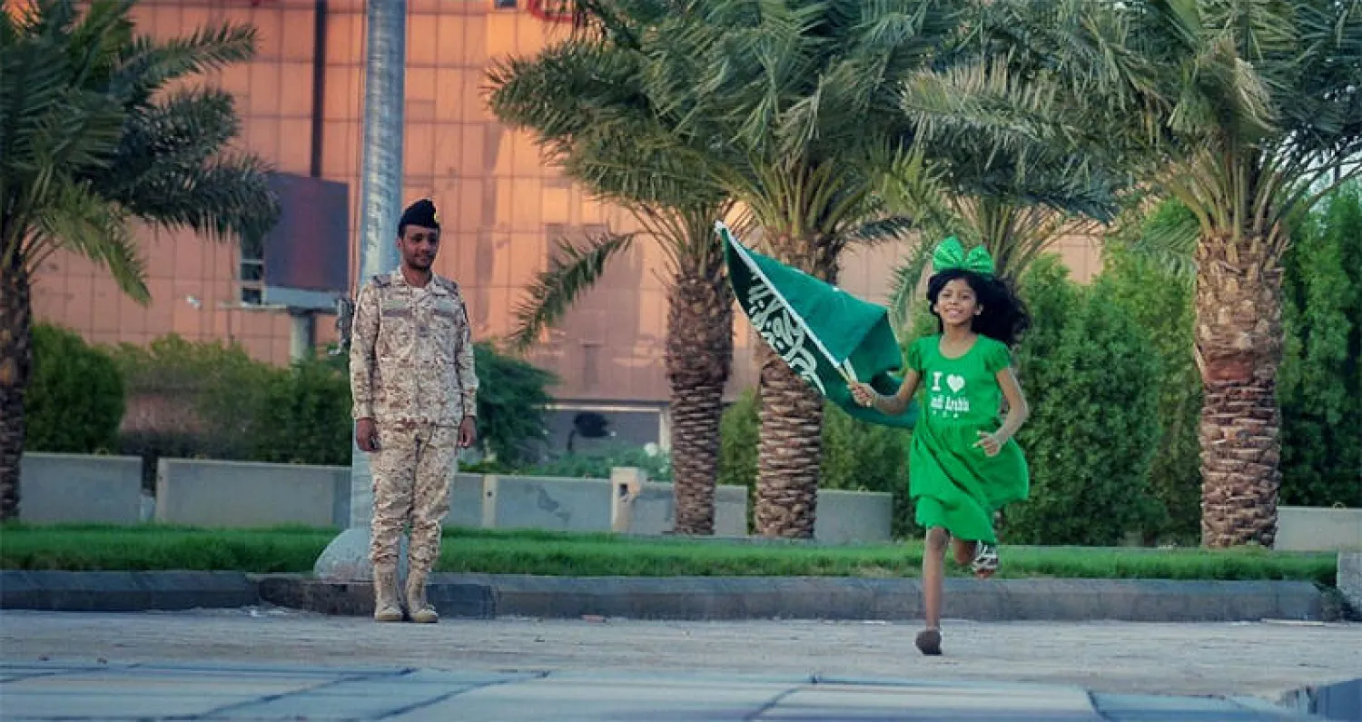 طفلة سعودية تحمل علم بلادها في إحدى فعاليات الاحتفالات الشعبية باليوم الوطني في الرياض أمس (واس)
