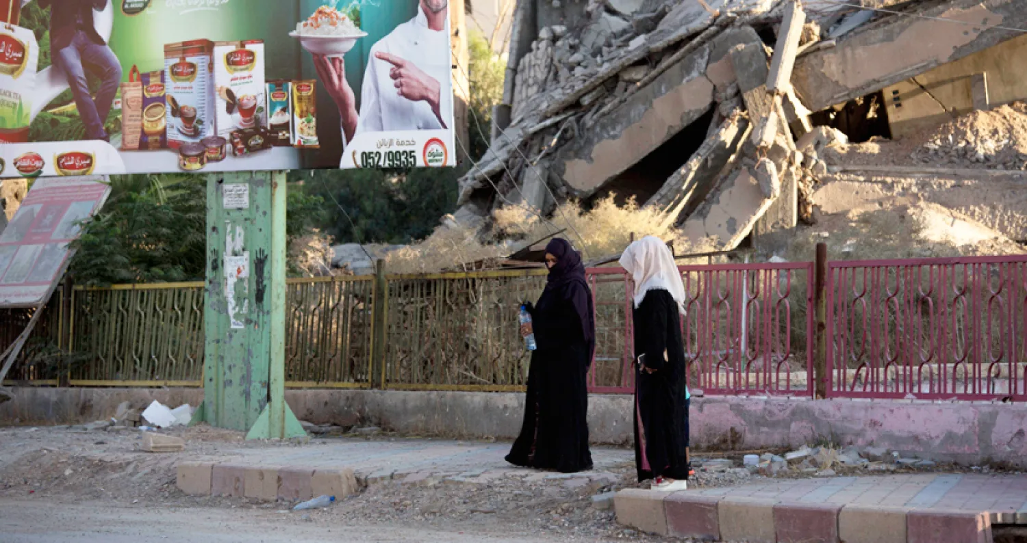 امرأتان في مدينة الرقة وسط الدمار الذي تسبب به تنظيم «داعش» والمعارك ضده (أ.ف.ب)