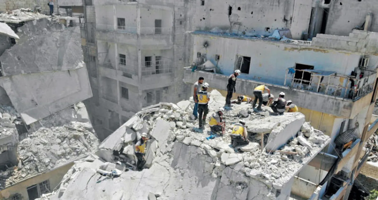 عناصر الدفاع المدني يبحثون عن الضحايا في موقع بأريحا جنوب إدلب تعرض لغارة جوية يوليو الماضي (أ.ف.ب)