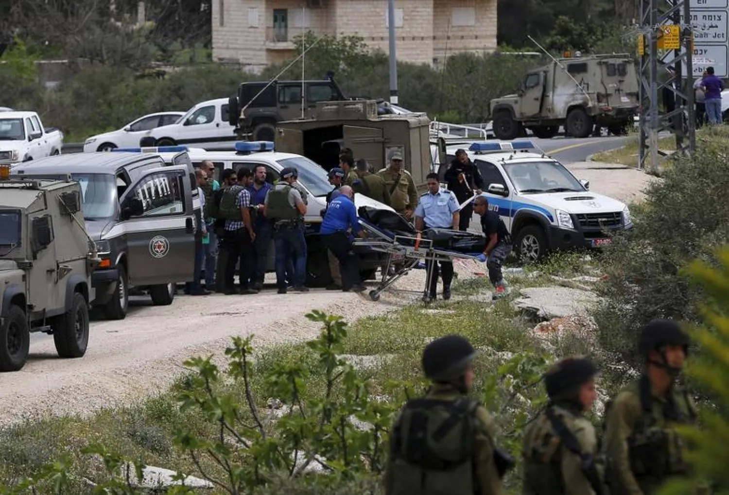 The dead body of a Palestinian who stabbed two Israeli soldiers is removed at the scene of the attack near the Jewish settlement of Maale Levona, near the West Bank city of Ramallah April 8, 2015. REUTERS/Ammar Awad


