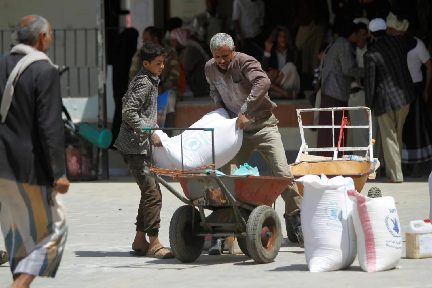 Workers carry the aid provided by the World Food Program (WFP) for distribution in Sanaa, Yemen August 21, 2019. REUTERS/Mohamed al-Sayaghi