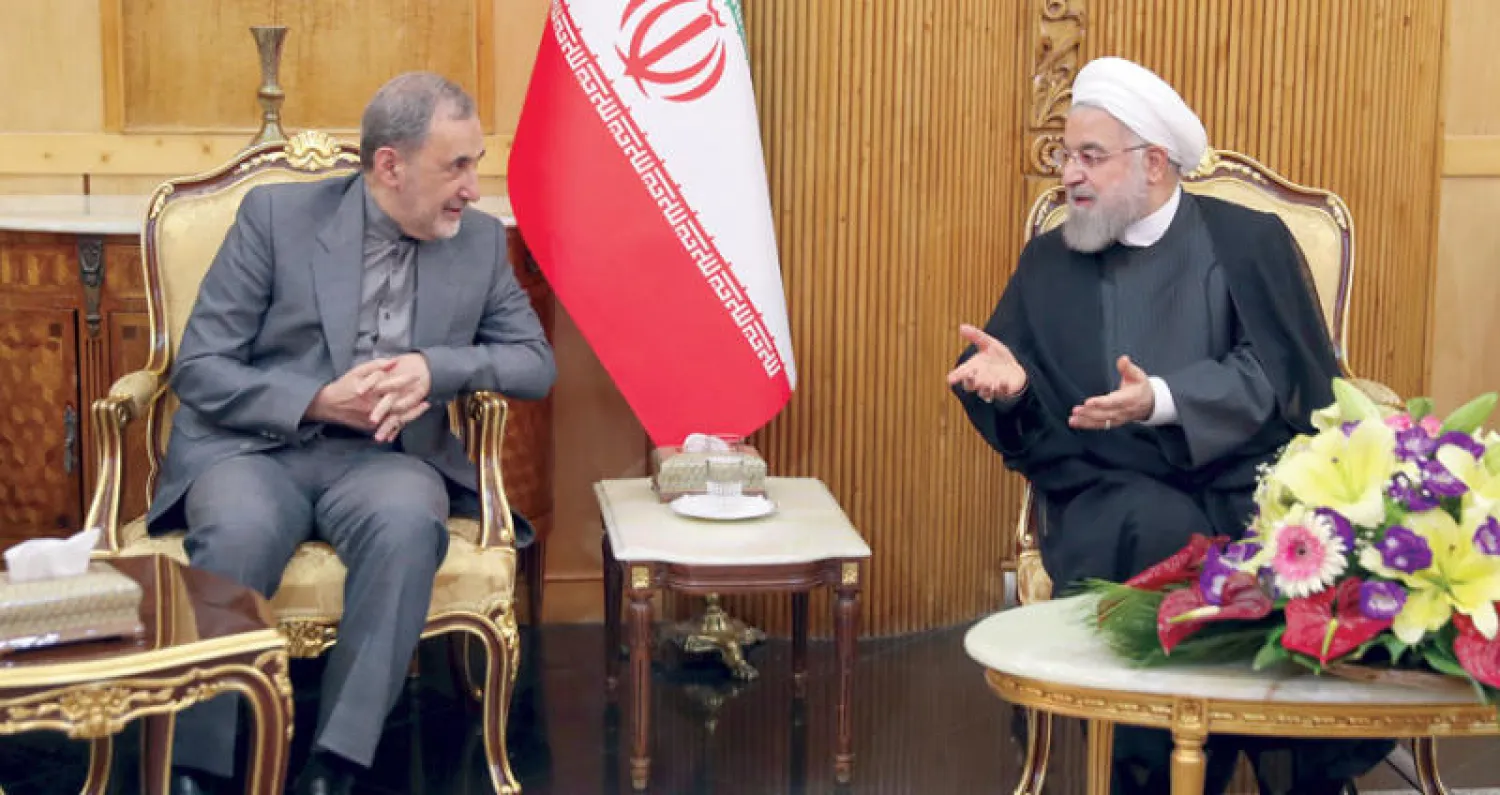 الرئيس الإيراني يتحدث إلى علي أكبر ولايتي مستشار المرشد الإيراني للشؤون الدولية في مطار مهرآباد في طهران أمس (أ.ب)