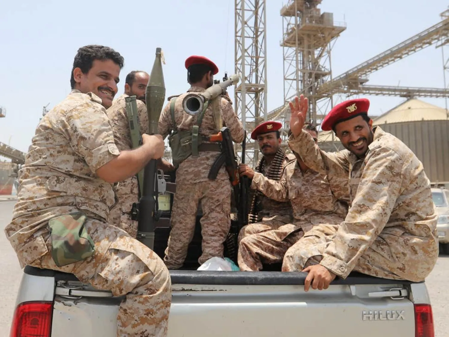 Houthis ride in the back of a vehicle during their withdrawal from Saleef port in Hodeidah (Reuters)