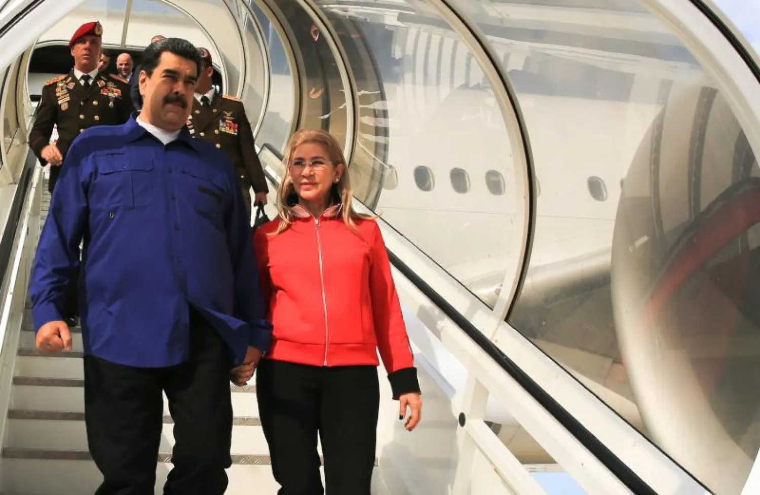 الرئيس الفنزويلي نيكولاس مادورو وزوجته سيليا فلوريس في مطار سيمون بوليفار بعد عودتهما من موسكو (أ.ف.ب)