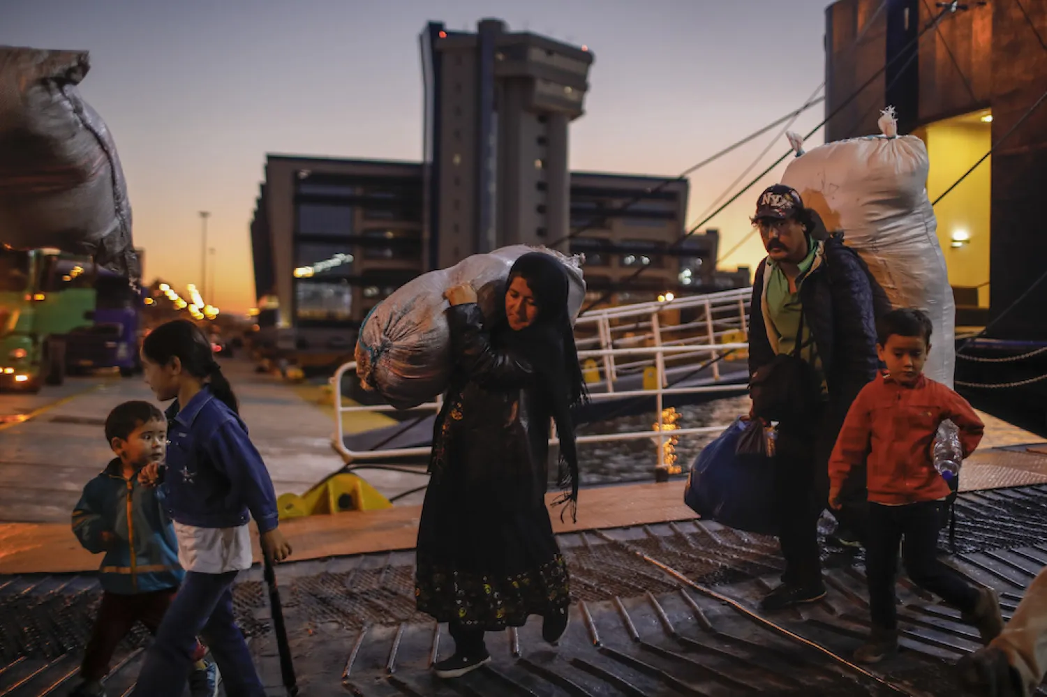 Refugees and migrants disembark from a ferry at the port of Piraeus, near Athens, Tuesday, Oct. 1, 2019. (AP Photo/Petros Giannakouris)