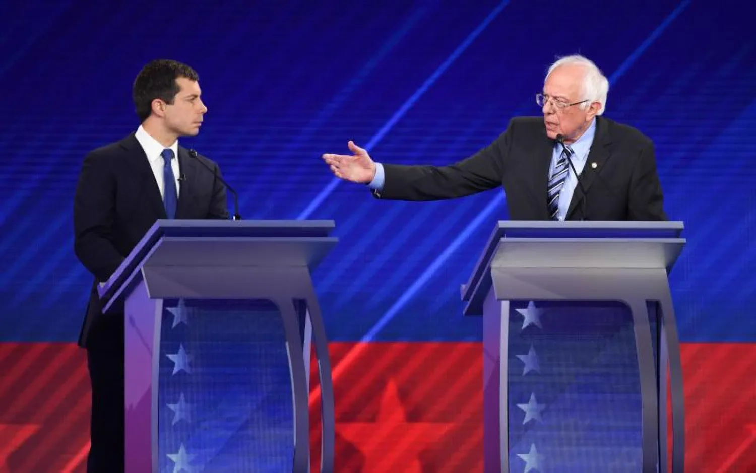بيرني ساندرز - إلى اليمين - وبيت بوتيدجادج خلال مناظرة للمرشحين الديمقراطيين (أ.ف.ب)