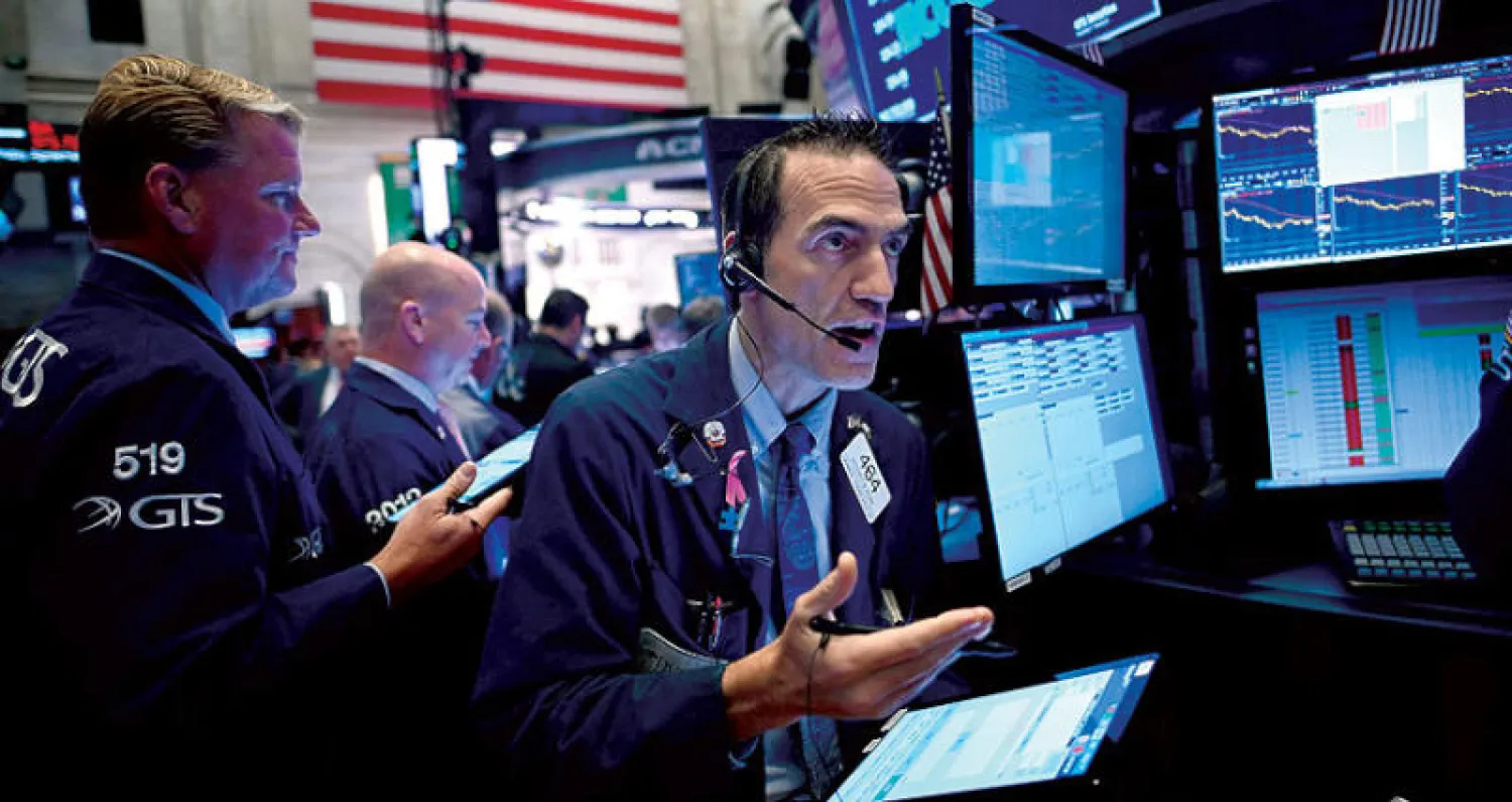 سماسرة يتابعون أسعار الأسهم في بورصة «وول ستريت» (أ.ف.ب)