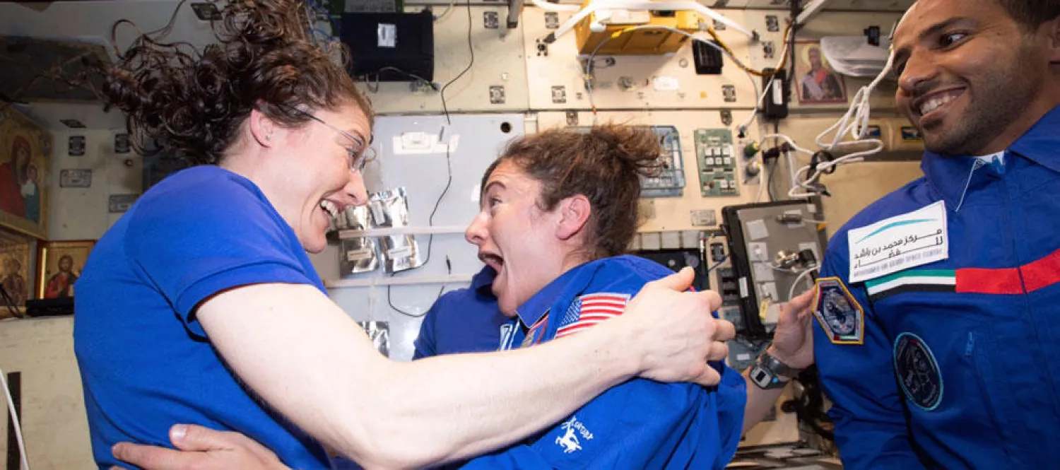 In this photo made available by NASA astronaut Jessica Meir on Sept. 29, 2019, Christina H. Koch, left, and Meir greet each other after Meir's arrival on the International Space Station. On Friday, Sept. 4, 2019, NASA announced that the International Space Station's two women will pair up for a spacewalk on Oct. 21 to plug in new batteries. (NASA via AP)