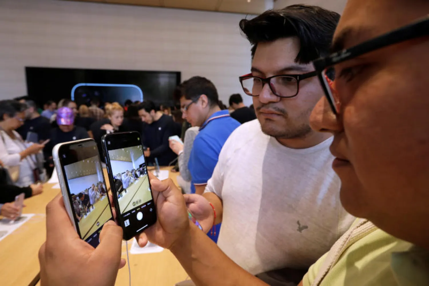 زبائن يختبرون هاتف «آيفون 11» في المكسيك (رويترز)