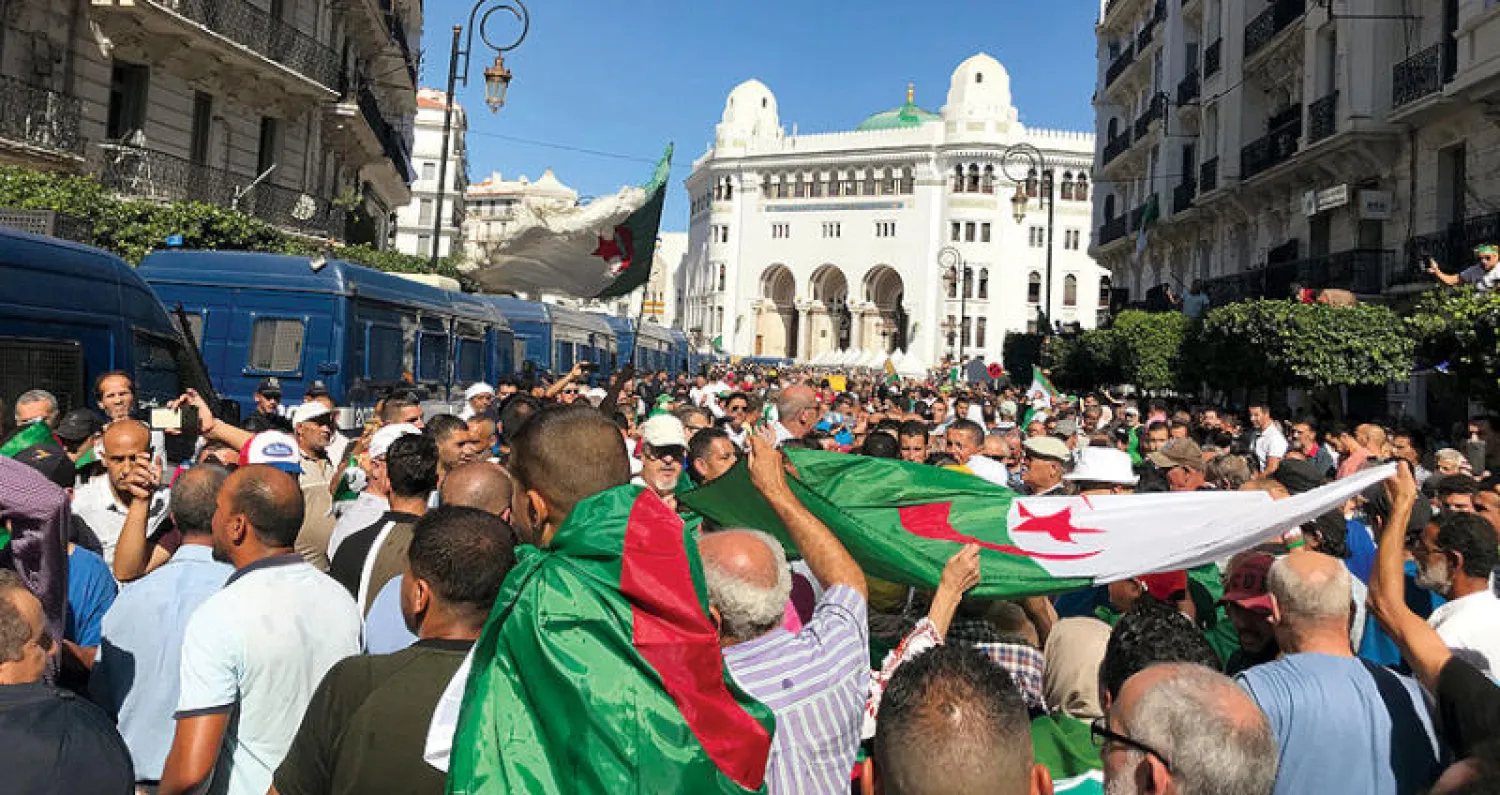 متظاهرون يرفعون الأعلام الجزائرية في العاصمة الجمعة الماضي (رويترز)