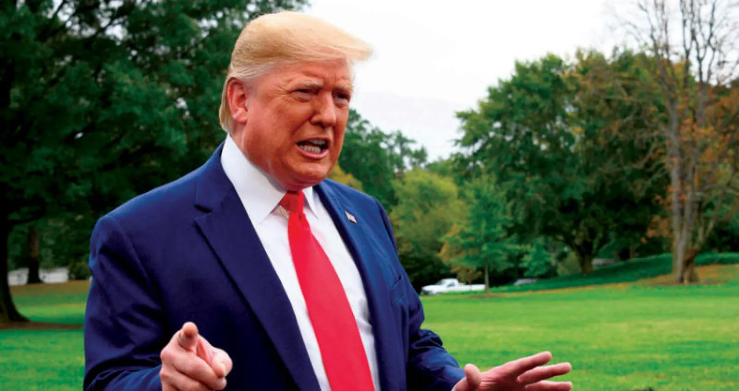 ترمب يتحدث عن إجراءات العزل مع صحافيين خارج البيت الأبيض الأسبوع الماضي (أ.ف.ب)