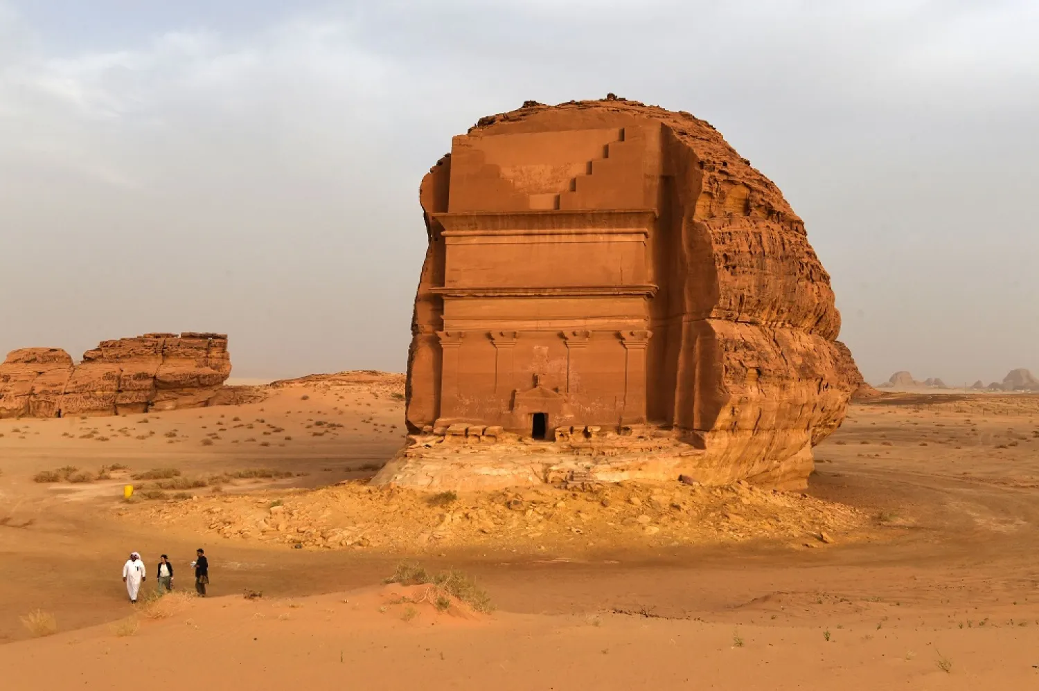 Men stand outside the Qasr al-Farid tomb in Madain Saleh, a UNESCO World Heritage site, near Saudi Arabia's northwestern town of al-Ula. (AFP)