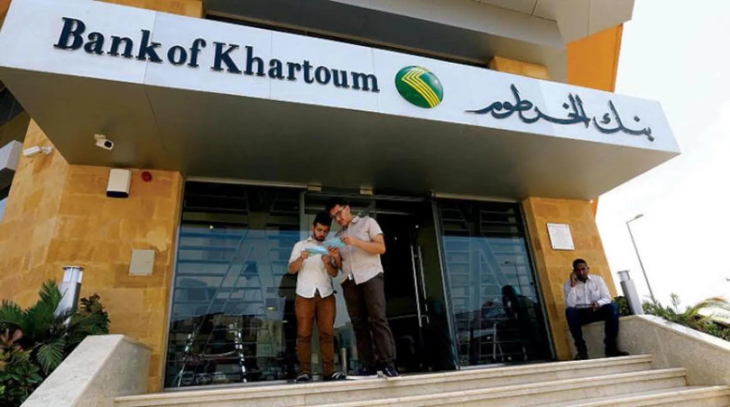People stand outside Bank of Khartoum branch