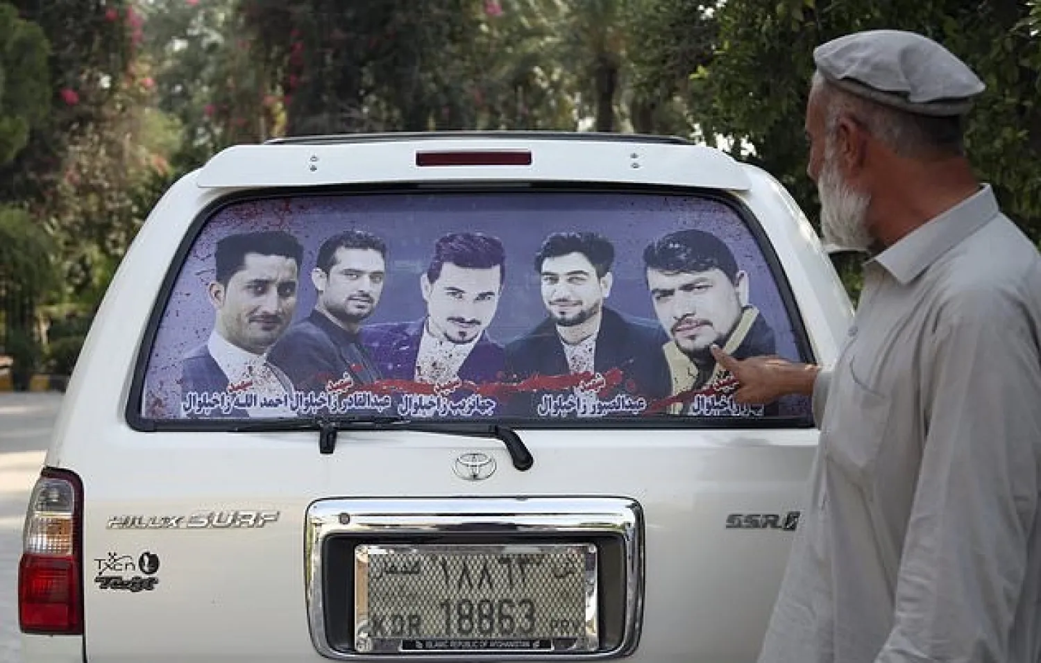 In this Tuesday, Oct. 1, 2019, photo, Zakhiwal's uncle, Mohammad Yaqoob Malikzada shows pictures of four brothers in the back of his car, who ware killed during a raid by the Afghan soldiers trained by CIA only known as Unit 02 after an interview to the Associated Press in Jalalabad city east of Kabul, Afghanistan. (AP Photo/Rahmat Gul)
