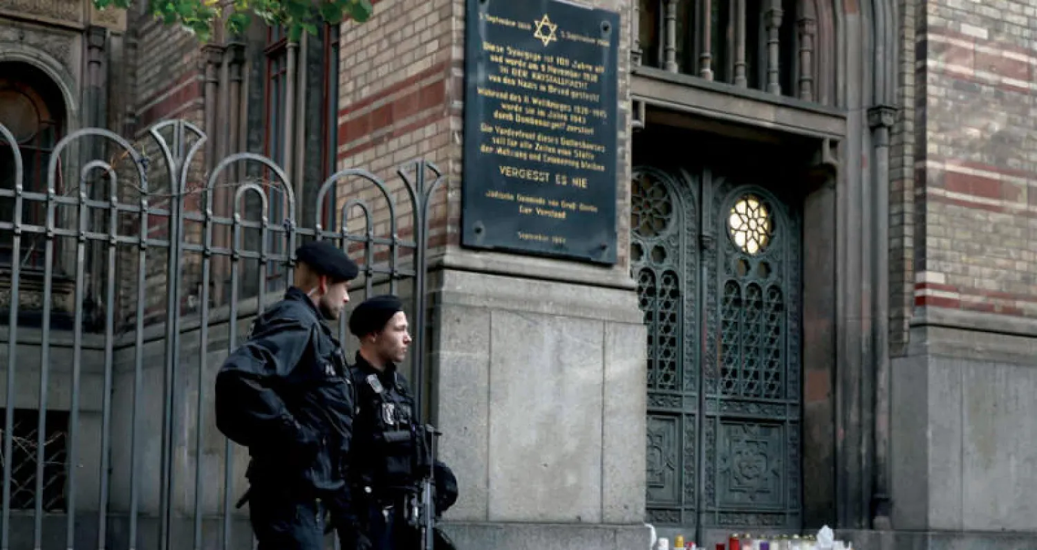 ضابطان من الشرطة الألمانية أمام مركز العبادة اليهودي في مدينة هاله بولاية ساكسونيا أمس (رويترز)