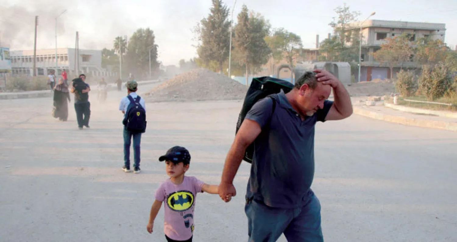 نازحون من مدينة رأس العين شمال شرقي سوريا أمس (إ.ب.أ)