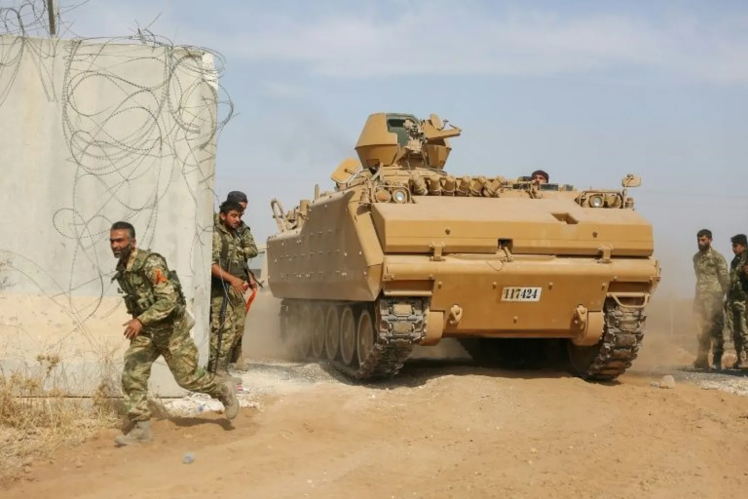 Pro-Turkish Syrian fighters drive an armored personnel carrier across the border into Syria as they take part in an offensive against Kurdish-controlled areas in northeastern Syria launched by the Turkish military, on October 11, 2019 | AFP