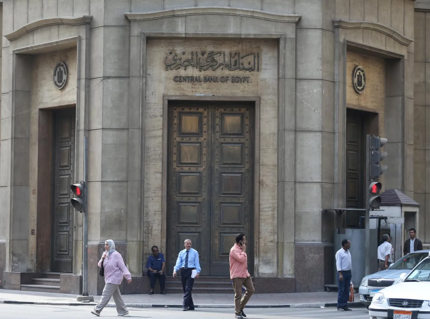 People walk in front of the Central Bank of Egypt's headquarters at downtown Cairo, Egypt, November 3, 2016. Picture taken Egypt, November 3, 2016. REUTERS/Mohamed Abd El Ghany