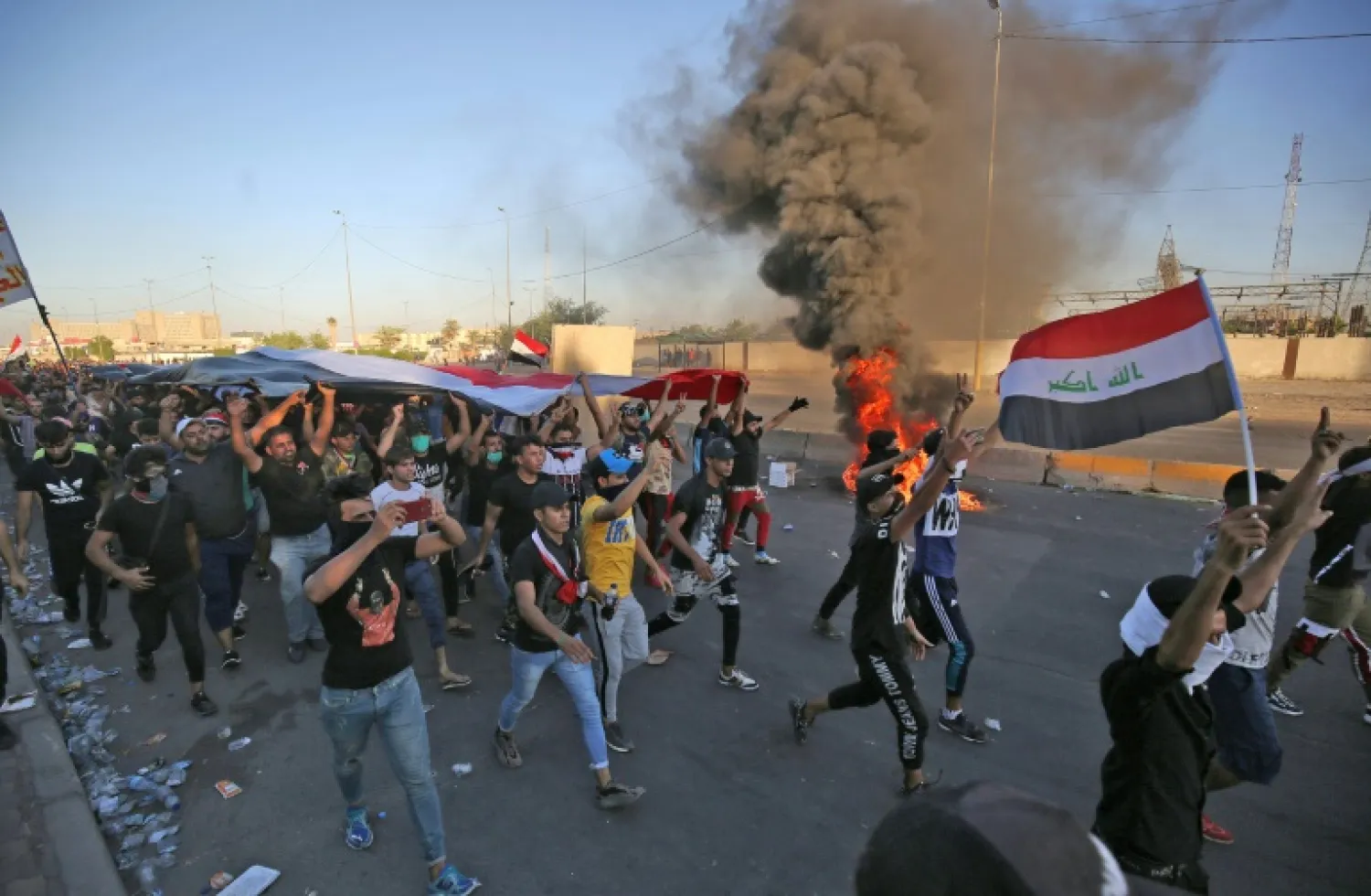 Protesters carrying Iraqi flag (AFP)
