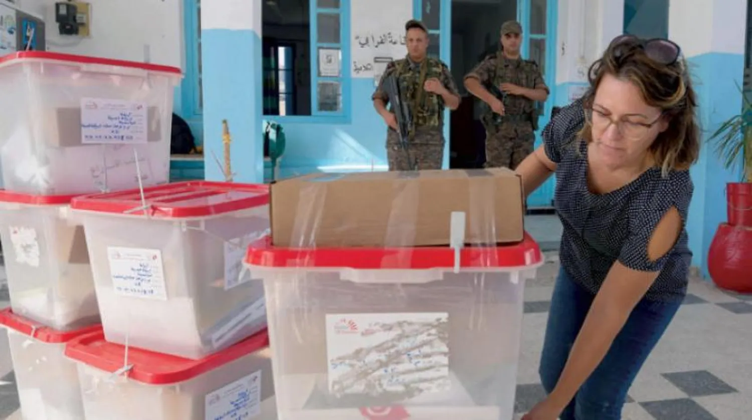 The director of a polling station in Tunis inspects the ballot boxes on Saturday, October 12, 2019 (AFP)