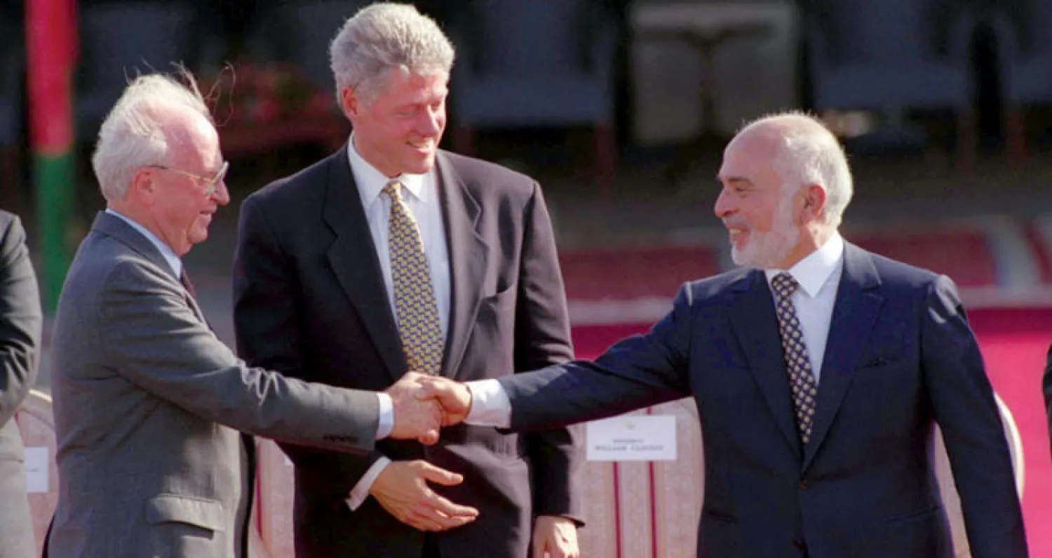 الرئيس الأميركي السابق بيل كلينتون متوسطا العاهل الأردني الملك حسين ورئيس الوزراء الإسرائيلي إسحاق رابين خلال توقيع اتفاق السلام بين إسرائيل والأردن عام 1994 في البيت الابيض (غيتي)