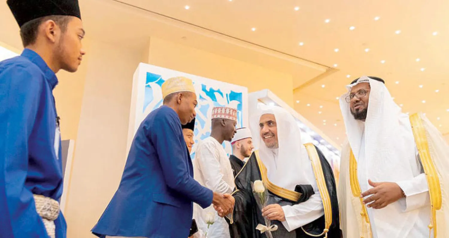 طلاب «الهيئة» من دول مختلفة في استقبال الدكتور العيسى خلال الملتقى الذي أقيم في مكة المكرمة (الشرق الأوسط)