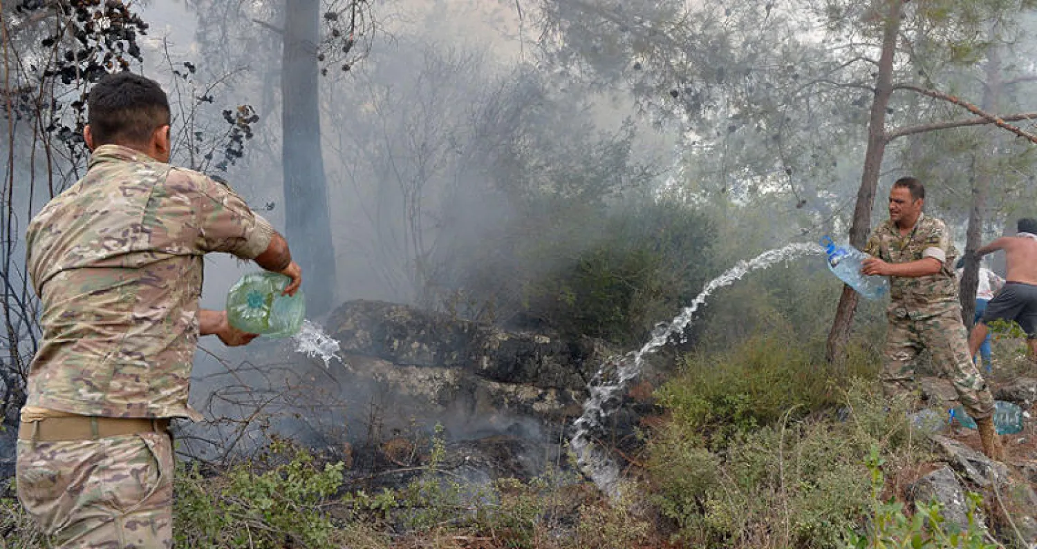 عنصران من الجيش اللبناني يحاولان إخماد حريق في منطقة المشرف جنوب بيروت (إ.ب.أ)