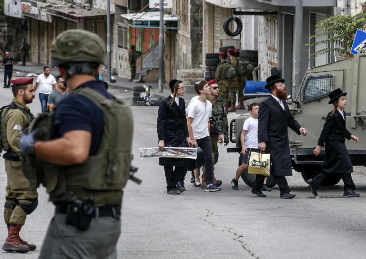مستوطنون وأفراد من قوات الأمن الإسرائيلية في الضفة الغربية (أ.ف.ب)