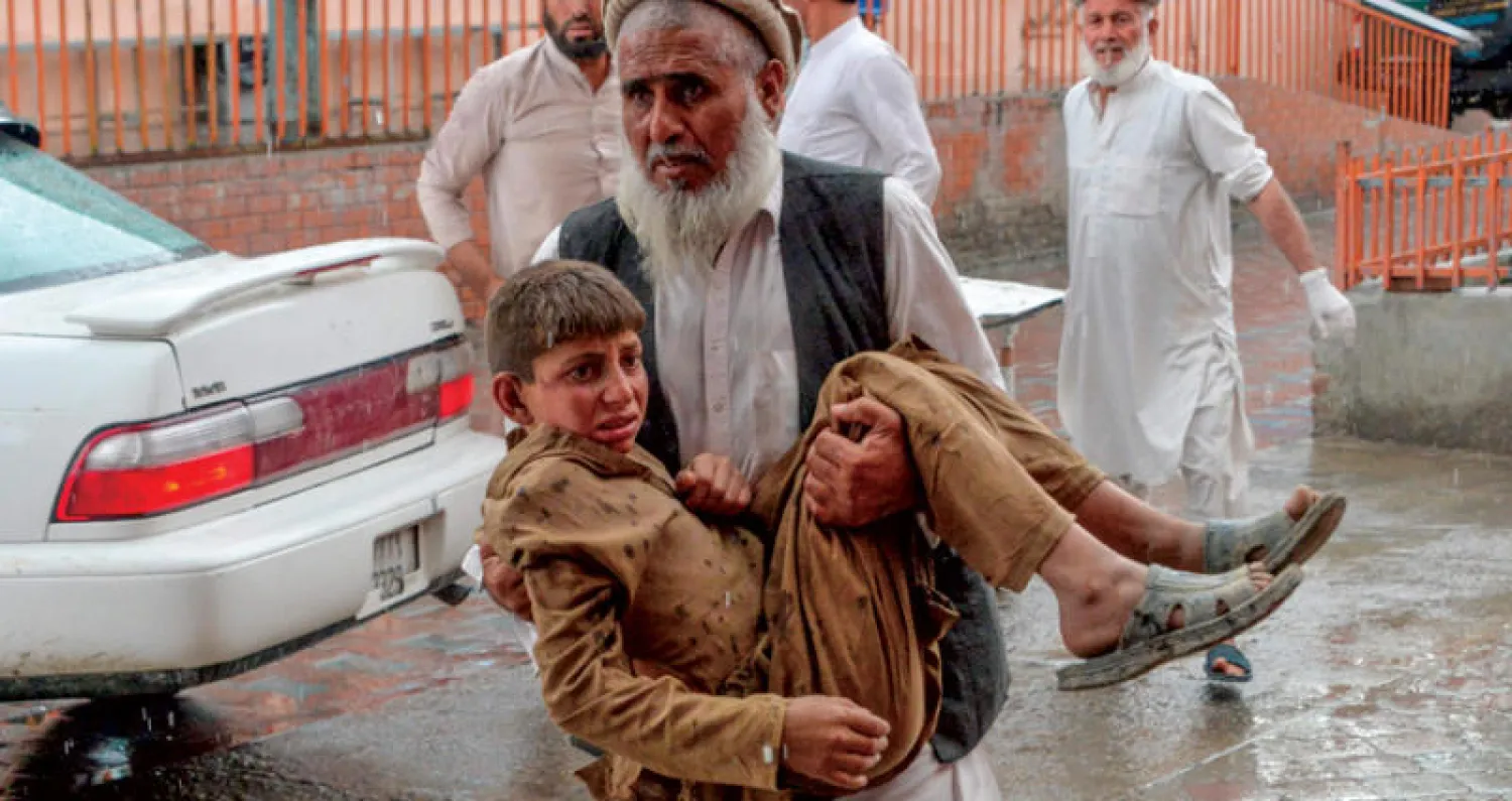 إنقاذ أحد الضحايا من تفجير مسجد خلال صلاة الجمعة في أفغانستان أمس (أ.ف.ب)