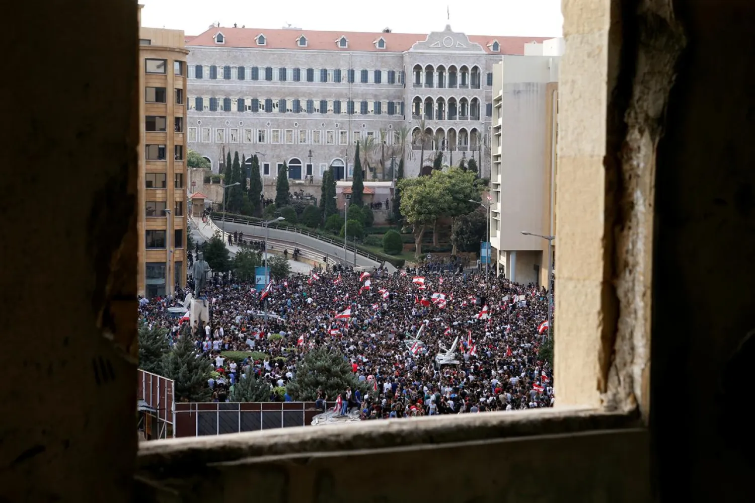 Demonstrators hold Lebanese flags as they gather during a protest in Beirut, Lebanon October 18, 2019. REUTERS/Mohamed Azakir