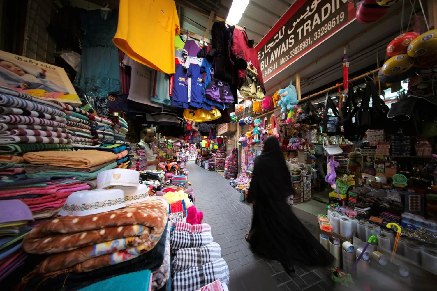 A Bahraini woman walks through a local market as she looks for clothes for her children ahead of Eid al-Adha in Manama, Bahrain, August 19, 2018. (Reuters)