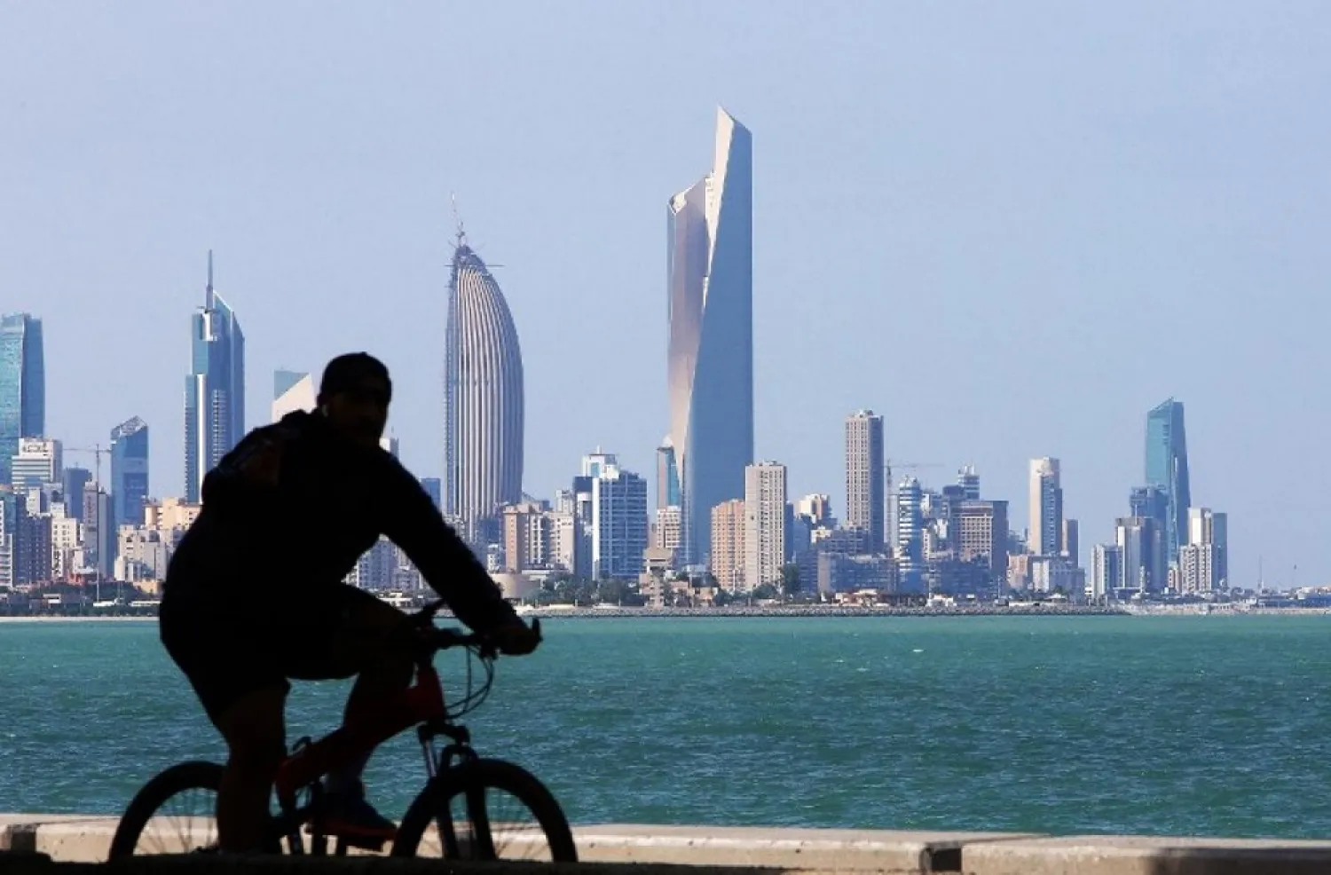 A cyclist rides along the seafront in Kuwait City. (AFP)