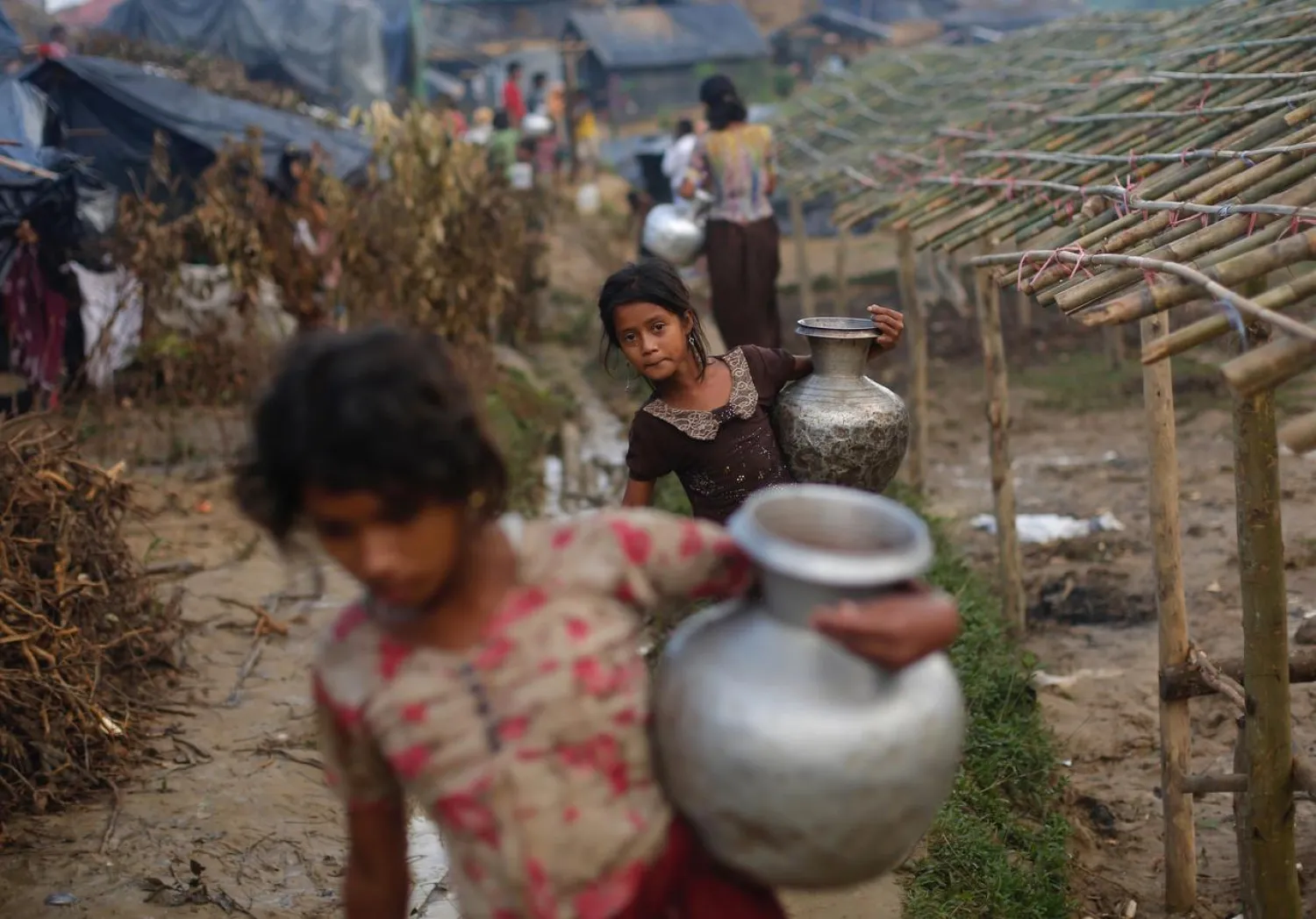 Rohingya refugee girls carry metal pitchers with water at Balukhali makeshift refugee camp in Cox's Bazar, Bangladesh, September 13, 2017. (Reuters)